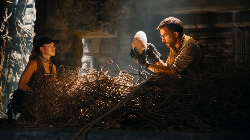 L to R: Scarlett Johansson as skilled covert operations expert Zora Bennett and Jonathan Bailey as paleontologist Dr. Henry Loomis in Jurassic World Rebirth