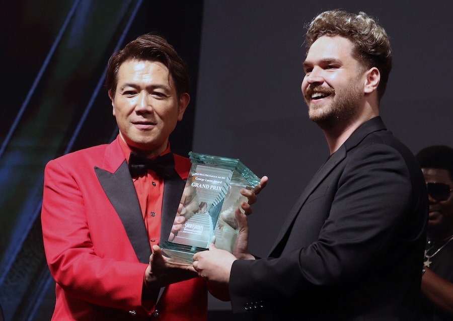 映画祭代表の別所哲也からトロフィを受け取る ©︎The Hollywood Reporter Japan