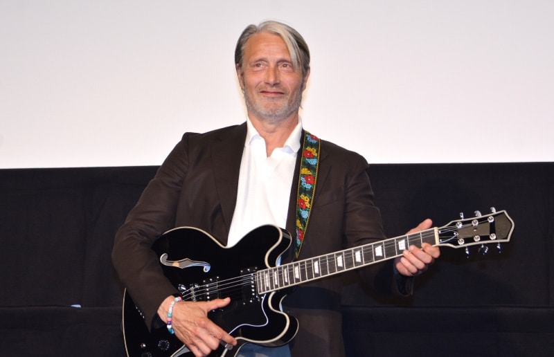 実際に舞台上でもギターを触ってマンフレルを再現するマッツ・ミケルセン 写真:The Hollywood Reporter Japan